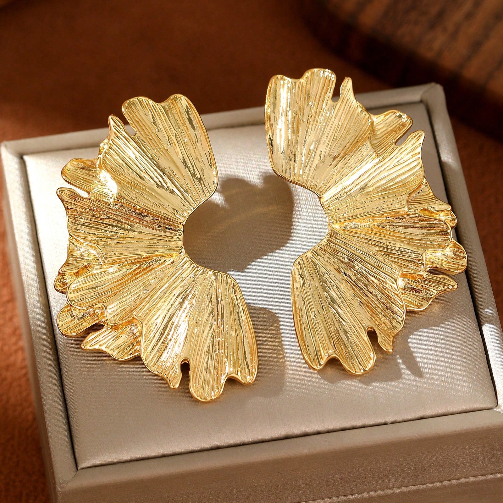 FAVEN Gold earrings worn by a person with a neutral background