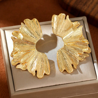 FAVEN Gold earrings worn by a person with a neutral background