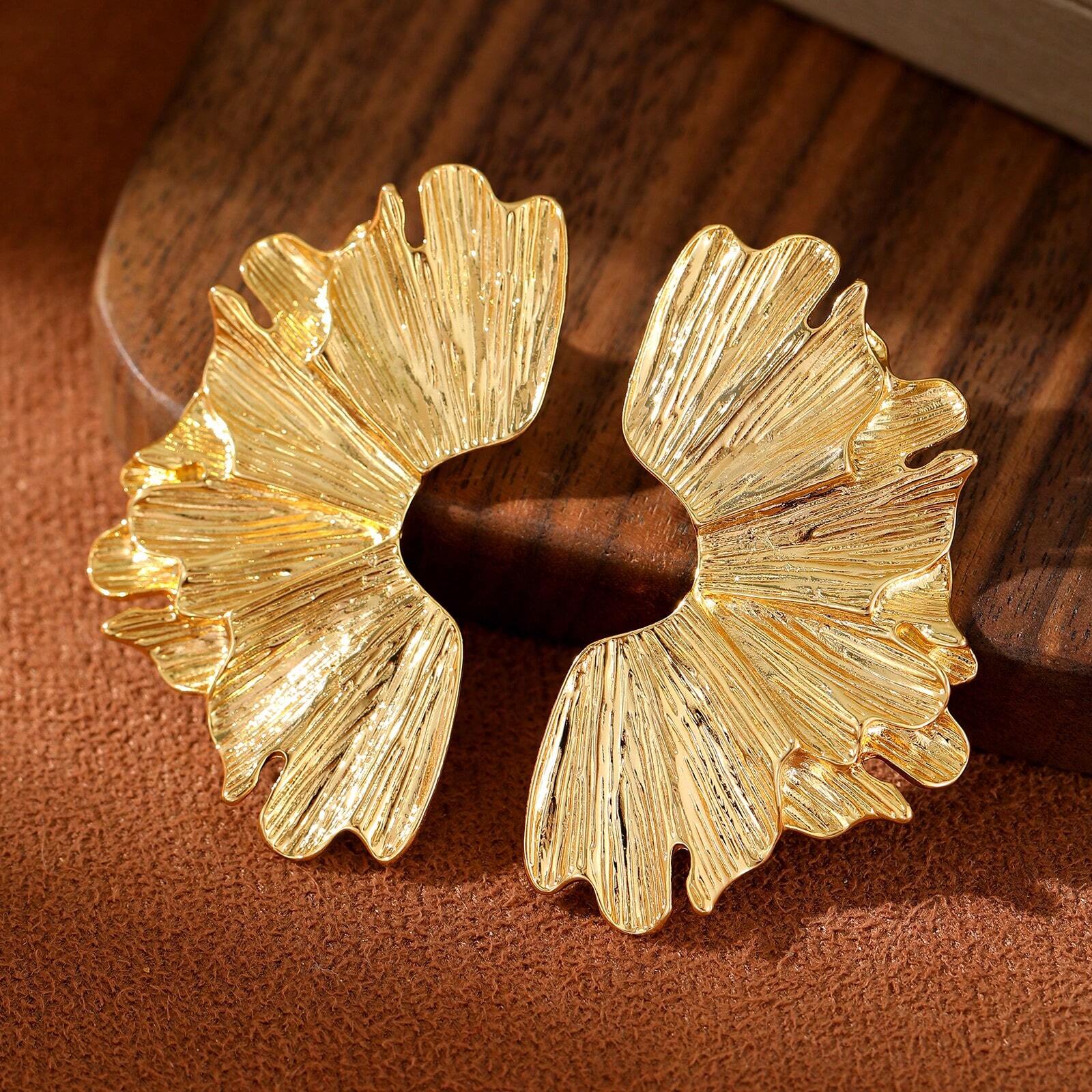 FAVEN Gold earrings worn by a person with a neutral background
