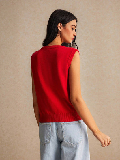 Woman wearing a red sleeveless sweater against a beige background