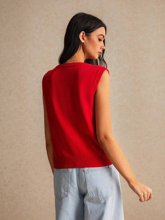 Woman wearing a red sleeveless sweater against a beige background