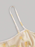 Yellow floral dress with thin straps on a gray background