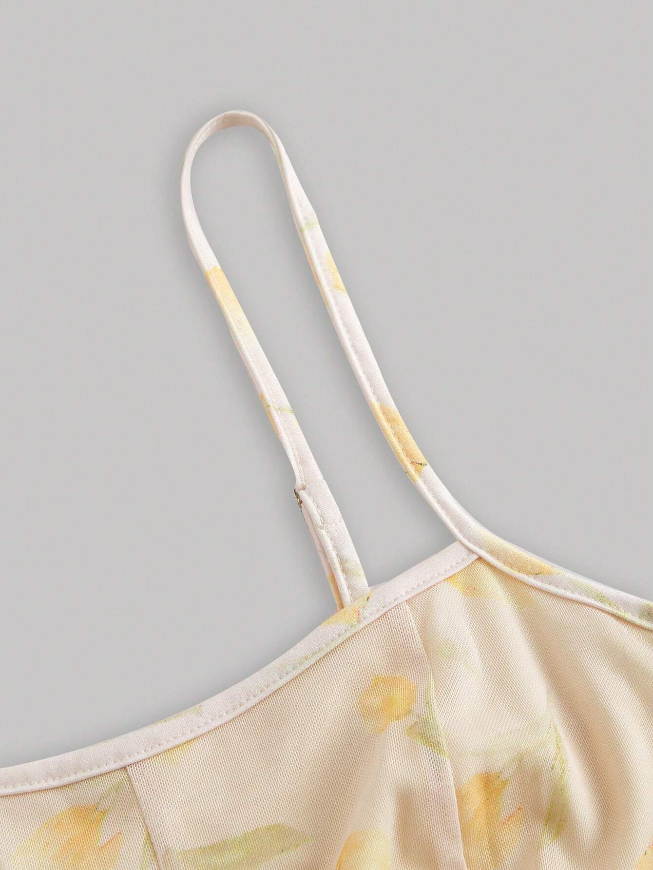 Yellow floral dress with thin straps on a gray background