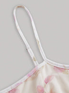 Close-up of a floral dress strap on a light gray background