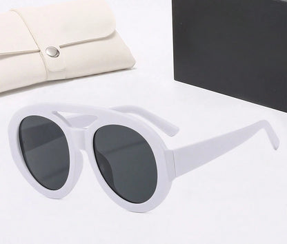 White sunglasses with dark lenses on a light surface