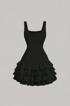 Black dress with ruffled skirt on a light gray background