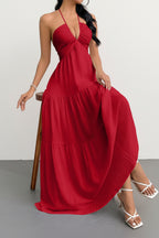 Woman wearing a red halter neck dress against a plain background