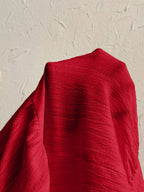 Red fabric draped over a textured beige surface