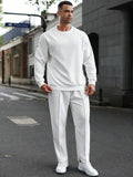 Man wearing a white outfit standing on a street.