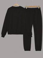 Black sweatshirt and pants set on hangers against a gray background