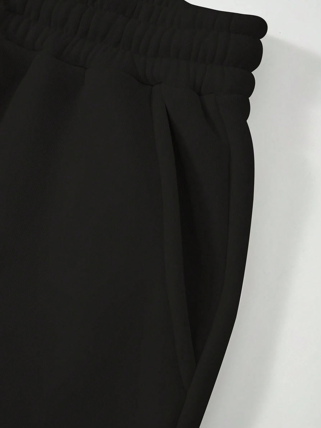 Close-up of black pants with a white background