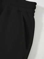 Close-up of black pants with a white background