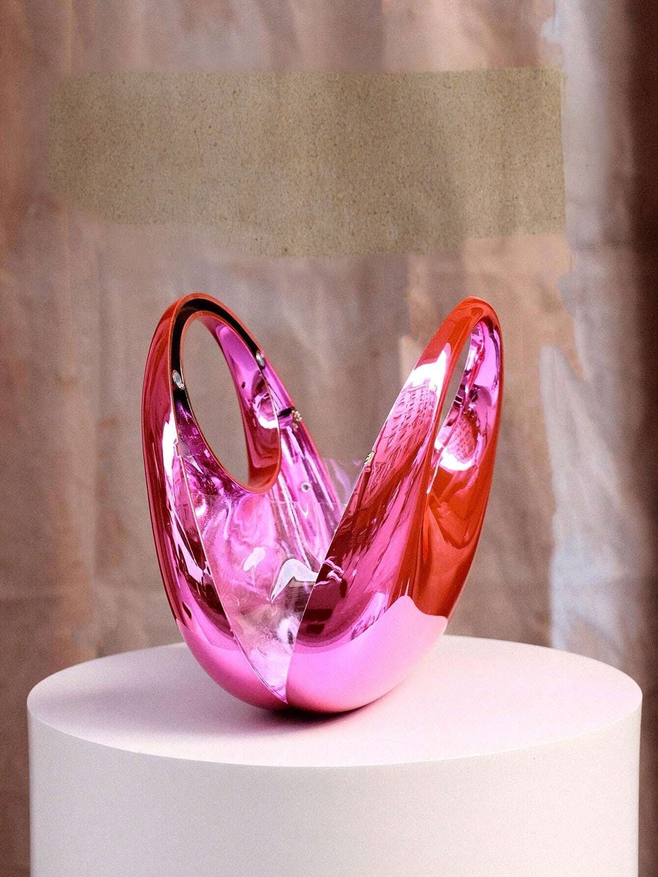 Pink glass sculpture on a white pedestal with a neutral background