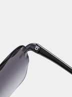 Close-up of a sunglasses frame with a reflective lens on a light gray background