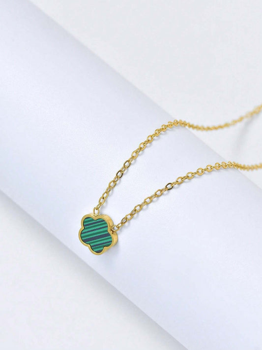 Gold necklace with a green pendant on a white background