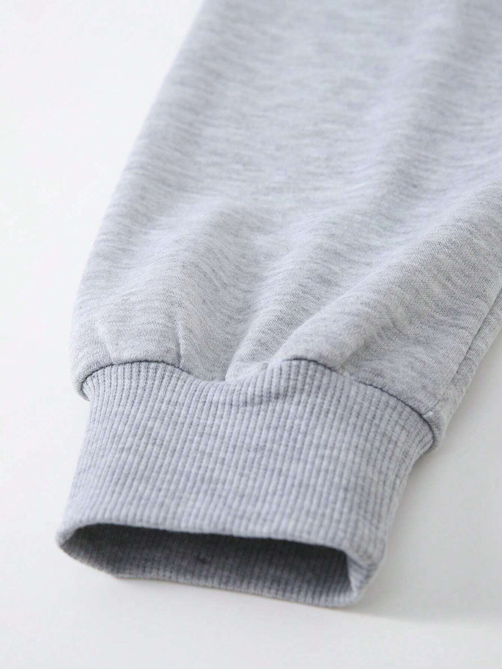 Close-up of a gray sweatshirt with ribbed cuffs on a white background