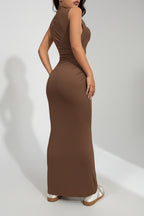 Woman wearing a brown sleeveless dress against a white backgroundl.