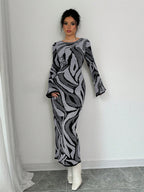 Woman wearing a patterned dress against a white wall