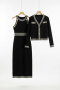 Black dress and cardigan set on hangers against a gray background