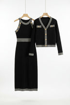 Black dress and cardigan set on hangers against a gray background