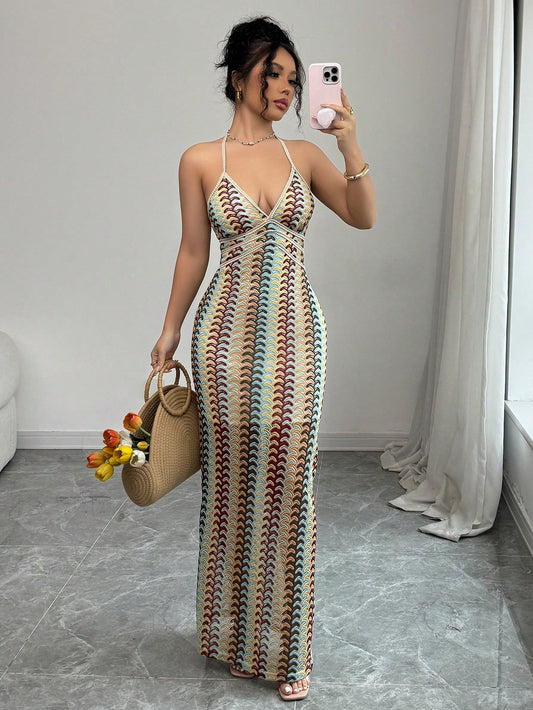 Woman in a patterned dress taking a mirror selfie in a room.