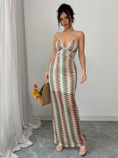 Woman wearing a colorful patterned dress holding a woven handbag indoors.