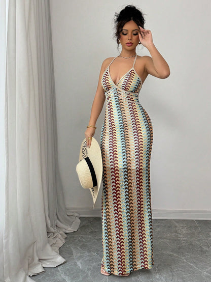 Woman wearing a patterned dress with a hat, standing against a plain background