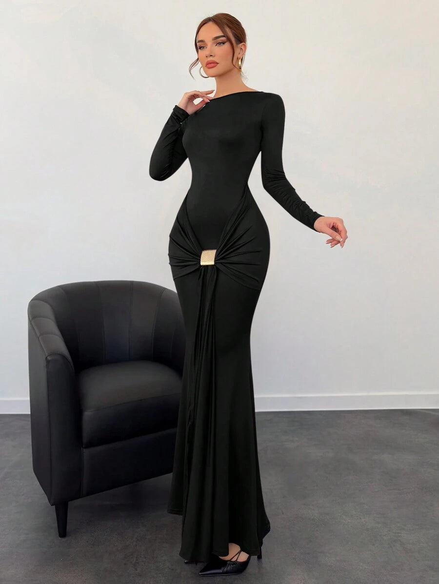 Woman wearing a black evening gown with a chair in the background