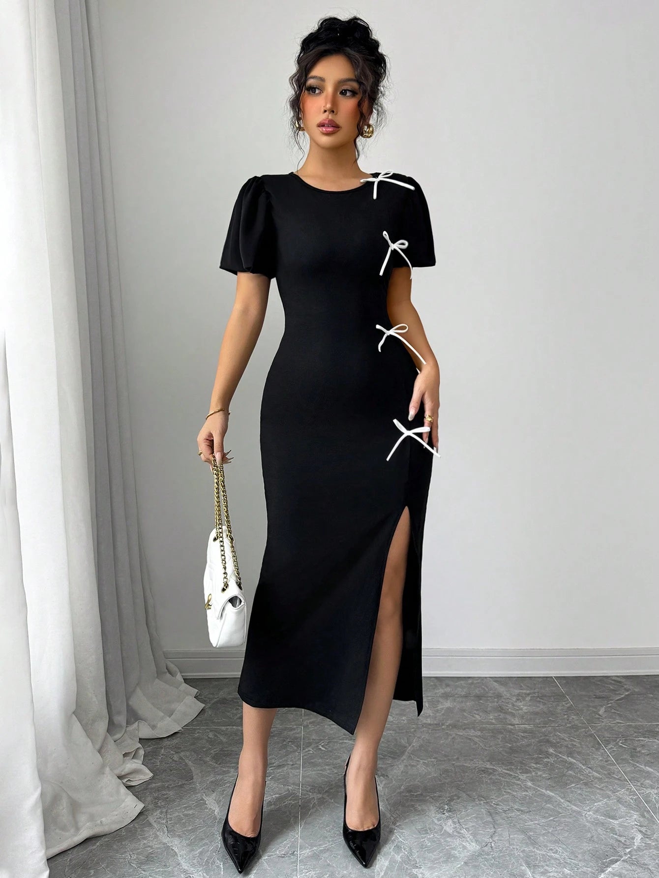 Woman wearing a black dress with white accents in an indoor setting