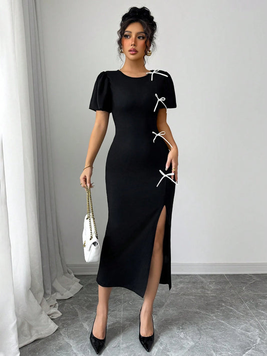 Woman wearing a black dress with white accents in an indoor setting