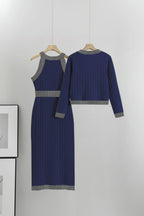 Navy blue dress with gray trim on hangers against a white background