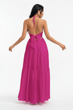 Woman wearing a pink dress with a white brick wall background