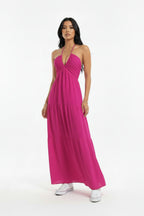 Woman wearing a pink halter neck dress against a white background