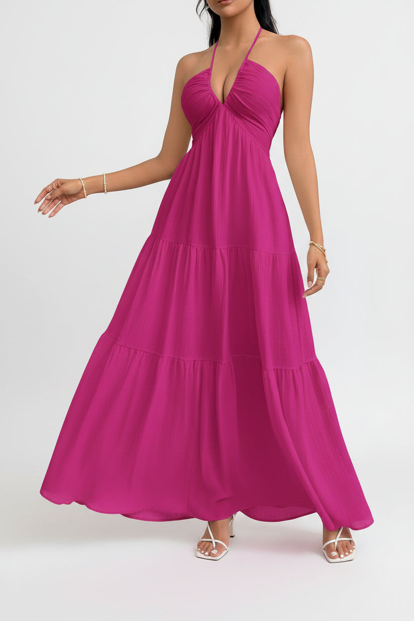 Woman wearing a pink halter neck dress on a gray background