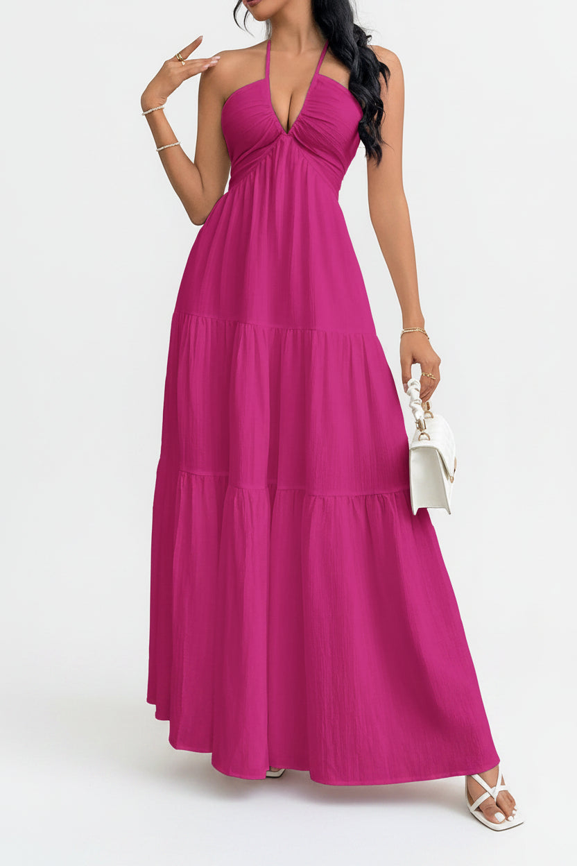 Woman wearing a pink halter neck dress against a white background