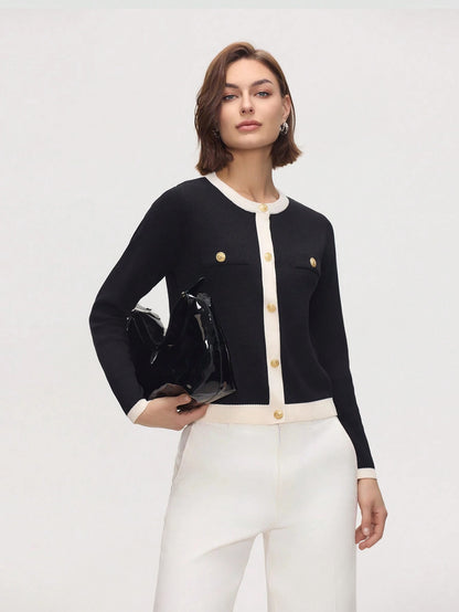 Woman wearing a black and white outfit with gold buttons on a white background