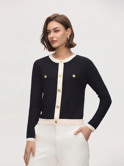 Woman wearing a black and white cardigan with gold buttons on a light gray background