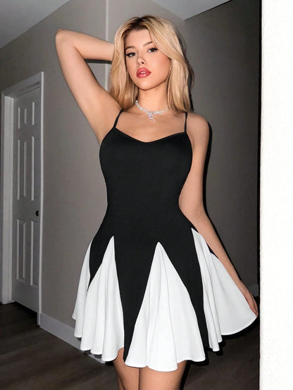 Woman wearing a black and white dress indoors.