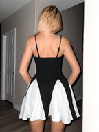 Person wearing a black and white dress in a room.