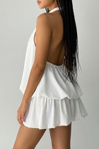 Woman wearing a white outfit with a plain background.