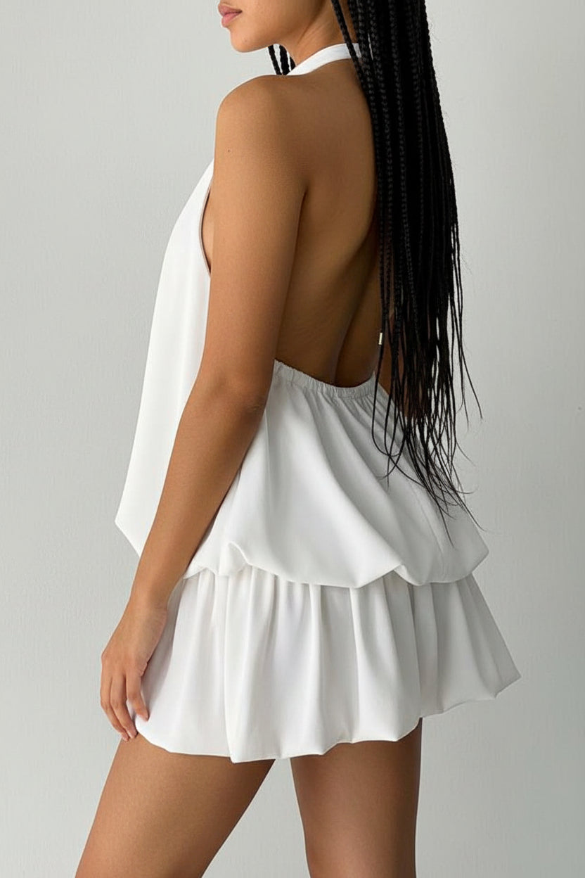 Woman wearing a white outfit with a plain background.