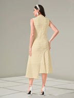 Woman wearing a light yellow dress with a textured pattern on a neutral background