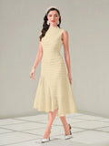 Woman wearing a light yellow dress with a plain background