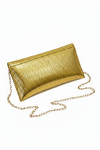 Gold metallic clutch bag with chain strap on a white surface