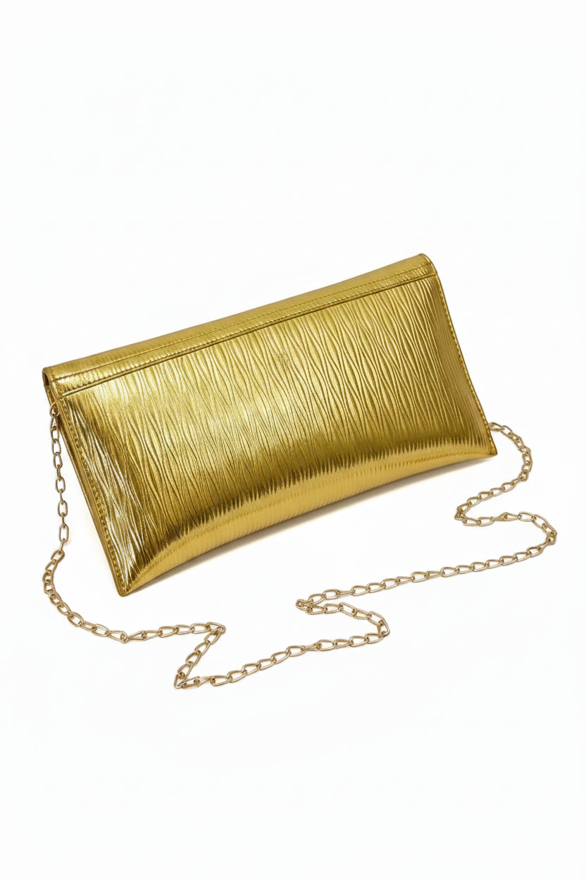 Gold metallic clutch bag with chain strap on a white surface