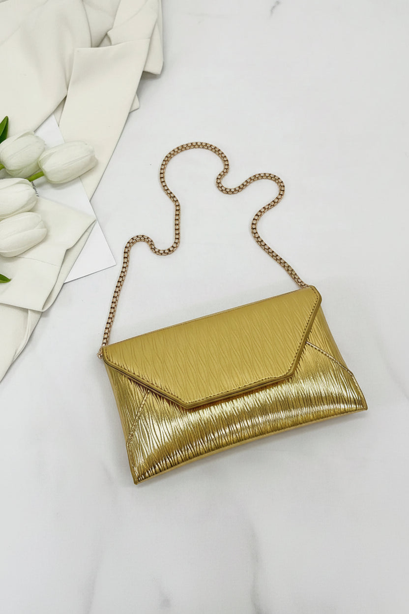 Gold clutch bag with chain strap on a white background with measurements indicated.