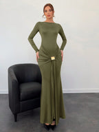 Woman wearing a green evening gown with a black chair in the background