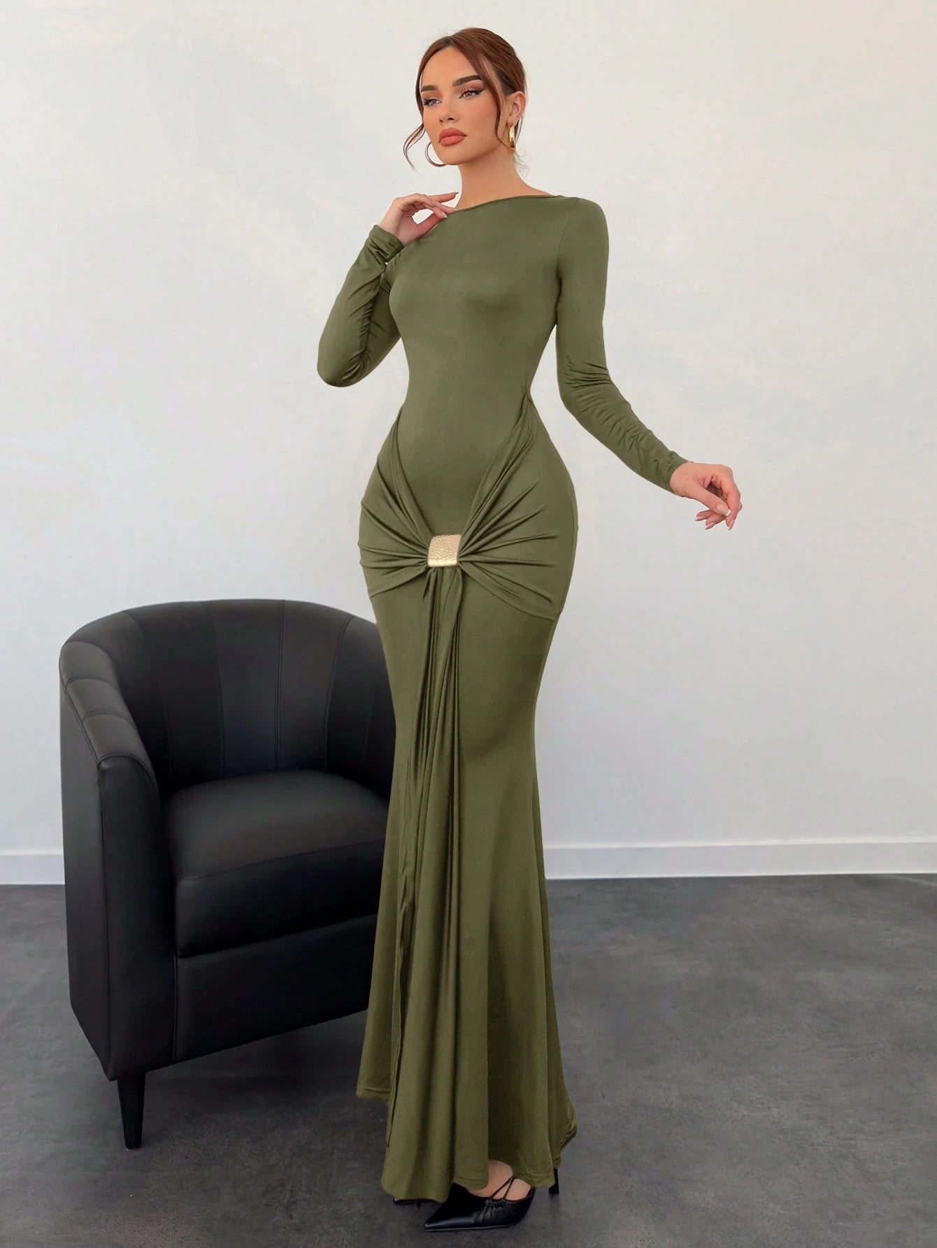 Woman wearing a green evening gown with a black chair in the background
