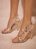 High-heeled sandals with leaf design on a neutral background