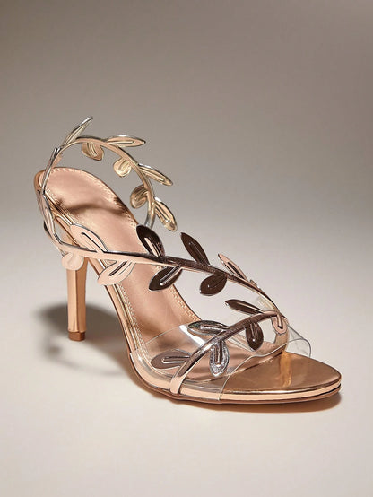 Rose gold high-heeled sandal with leaf-like straps on a neutral background